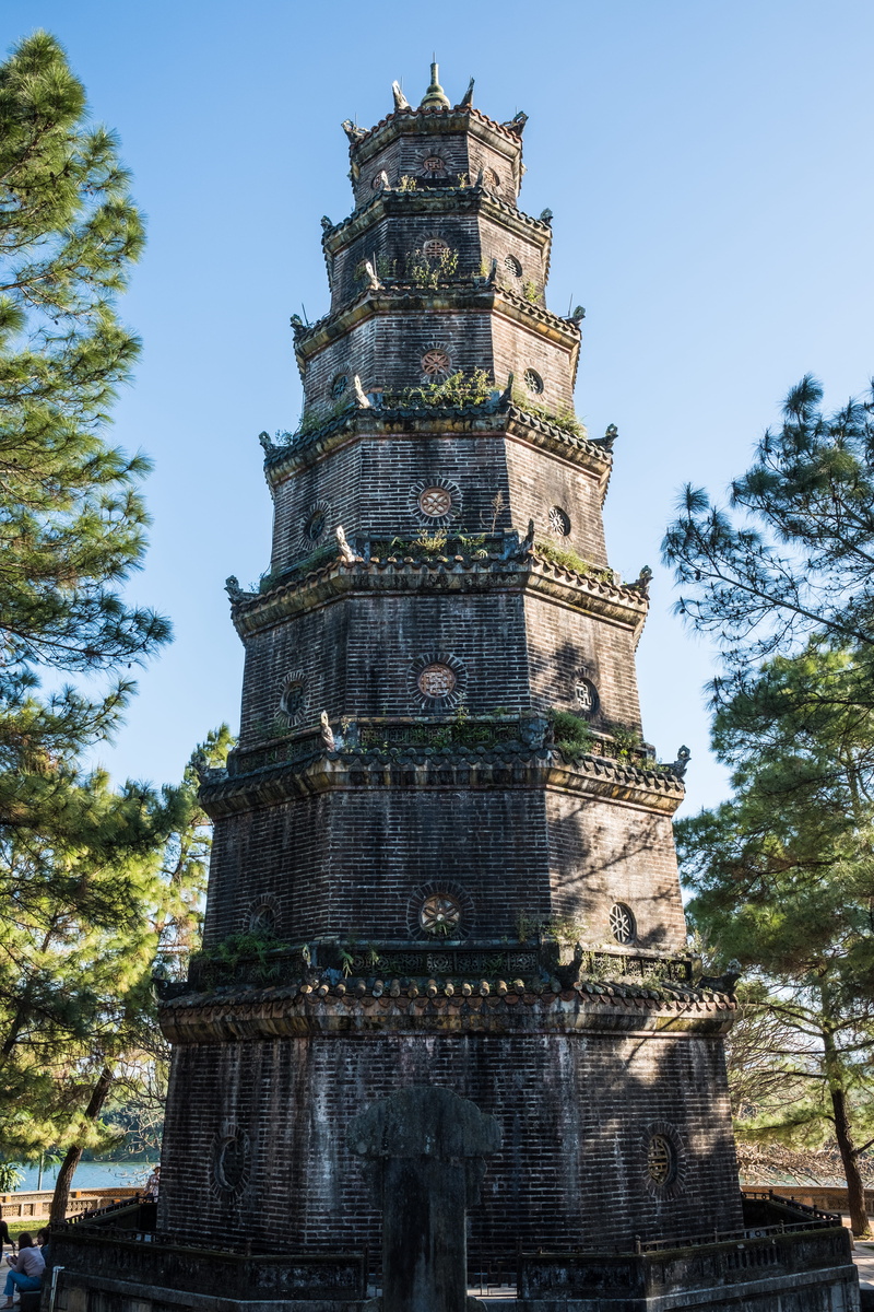travel destinations, temple, human, hui, plant, huế, trees, religion, metropolis, spire, worship, vietnam, sky, outdoors, person, built structure, history