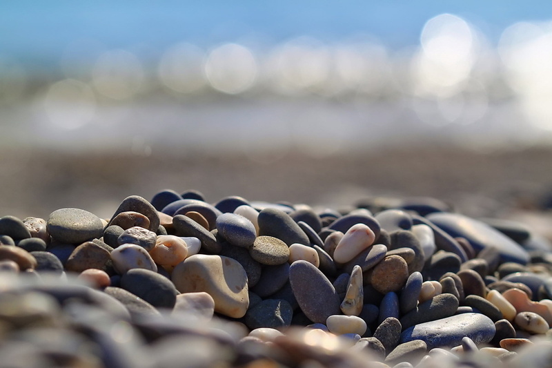 gravel, pebble, stone - Object, tranquility, lot, water, abundance, beach, pattern, rock, coastline, shape, no People, outdoors, sunlight, sea, summer