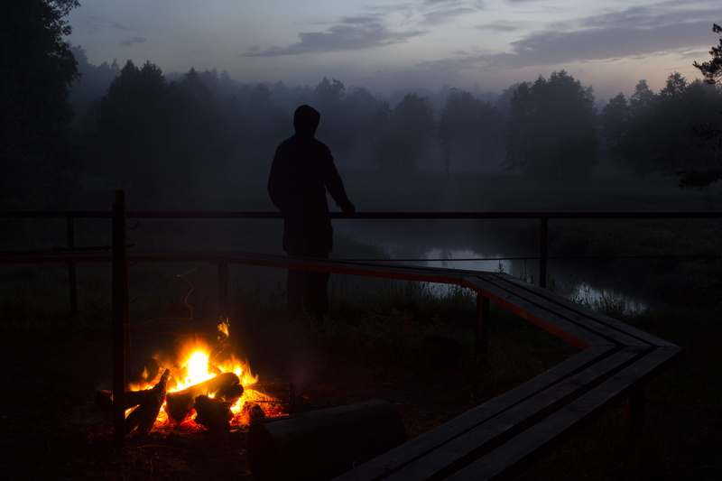 real people, leisure activity, bonfire, standing, sunset, campfire, log, men, water, one person, beauty in nature, flame, silhouette, outdoors, night, body