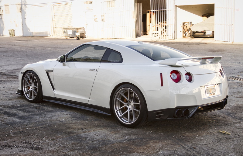 building, architecture, gate, gtr, motor vehicle, day, white color, vintage car, city, garages, car, parking, mode of transportation, no people, Nissan