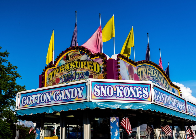 fair, city, canon, architecture, sign, popcorn, travel destinations, blue, day, food truck, nature, flag, western script, backdrop, text, blue sky, outdoors