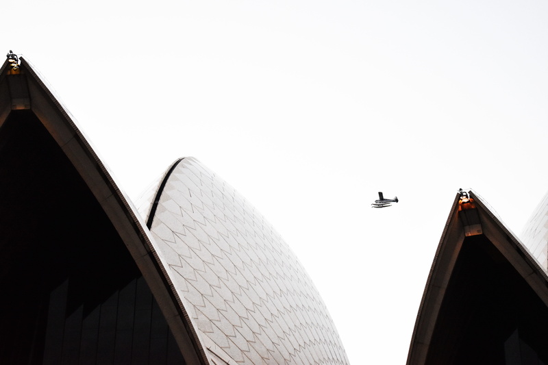 flying over opera house, nikon, sky, low angle view, outdoors, clear sky, machine, office building exterior, built structure, animal wildlife, sydney opera house
