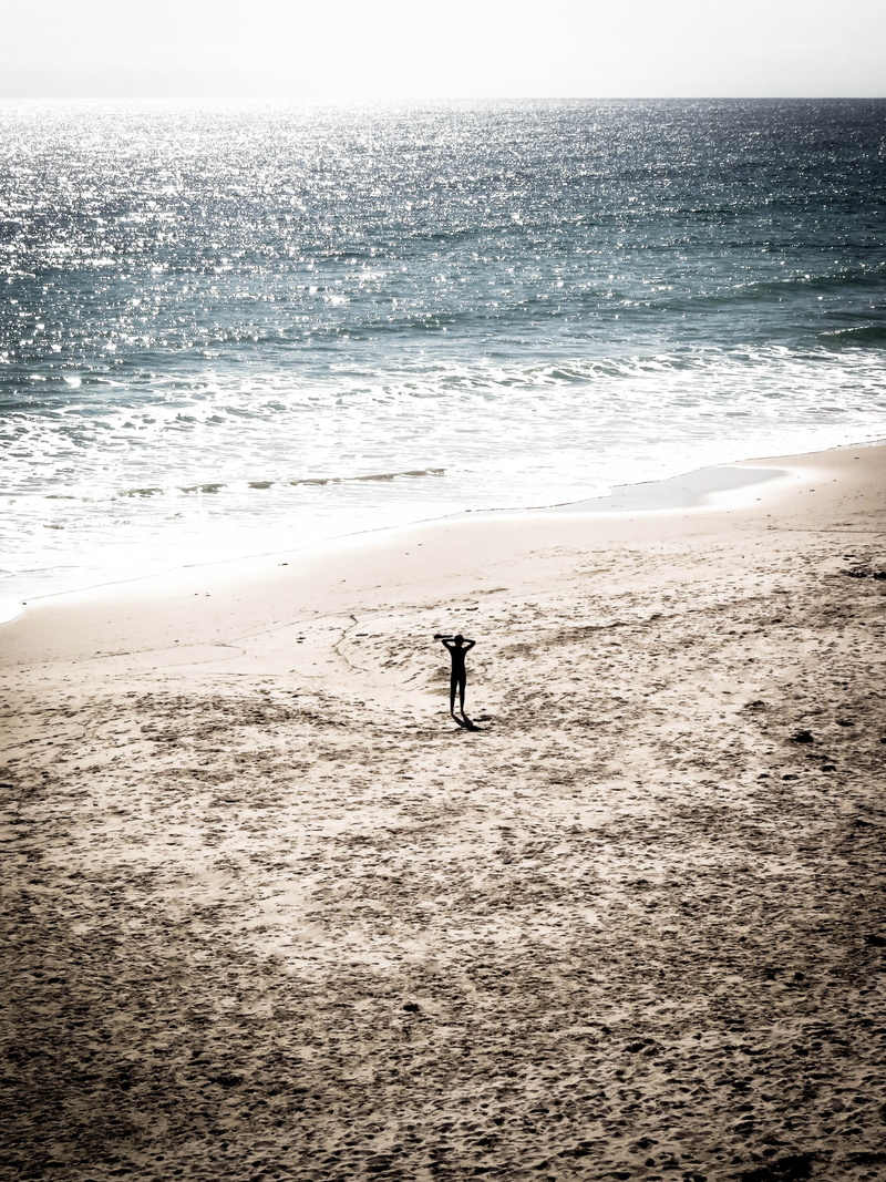 sand, near, person, silhouette, australium, standing, one person, ripple, real people, sparkling, land, beach, wave, hands on head, beauty in nature, nature