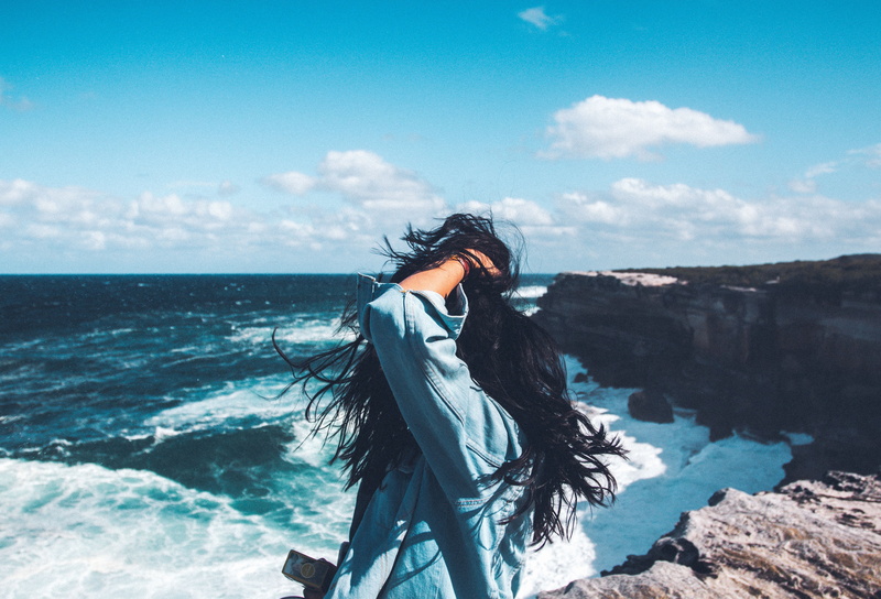 hands in hair, jean jacket, 5K, photography, waves, clouds, windy, women, coast, side view, back, sea, model, women outdoors, sky