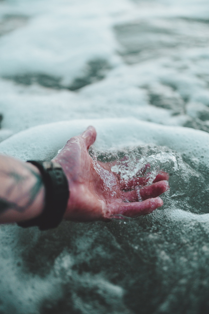 body part, human limb, low section, finger, human body part, holding, human foot, ocean, person, human hand, wave, close-up, personal perspective, sport