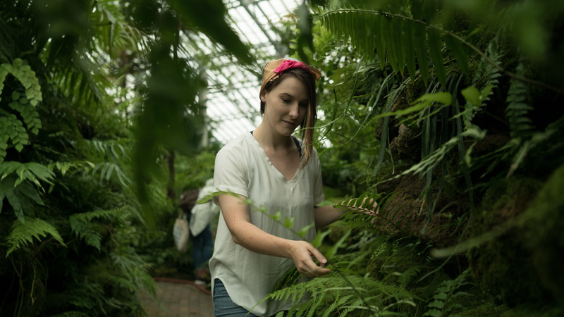 one person, gentle, outdoors, three quarter length, clothing, leisure activity, beautiful woman, standing, person, greenhouse, girl, focus, growth, beside