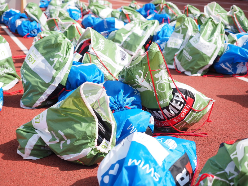 luggage bag, high angle view, numbered, plastic bag, clothes transport, no people, transport bag, day, green color, clothing, blue, blanket, plastic bags