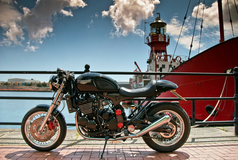 railing, people, sea, triumph thunderbird cafe racer, sunlight, city, land vehicle, day, mode of transportation, travel, red, motorcycle, water, bicycle