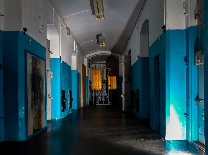 Barriers, built structure, door, architecture, flooring, Slammer, clothing, entrance, day, corridor, direction, illuminated, no people, arcade, absence