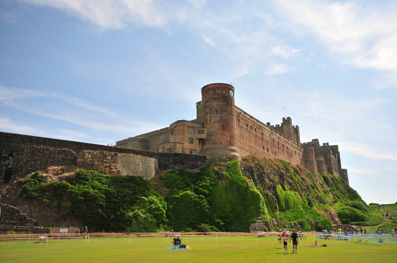 northumberland, travel destinations, history, nature, architecture, grass, group of people, fort, coast, building, day, outdoors, heritage, cloud - sky