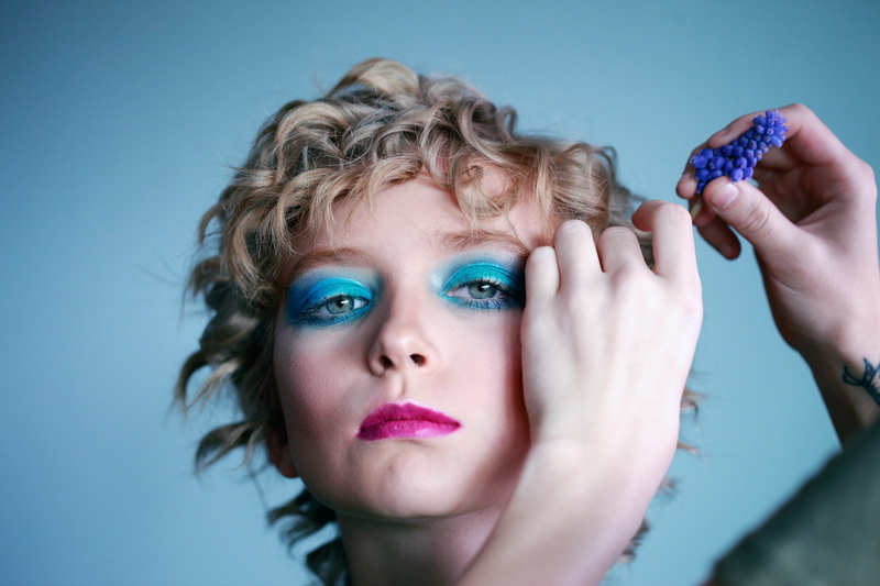 model, eyelashes, make-up, wearing, blue background, hair, youth, studio shot, looking at camera, contemplation, human body part, transgender, eyes, body part