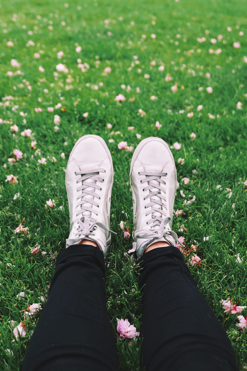 person, wearing, walking, laying, sport, grass, human Foot, gray, land, human limb, chill, one person, flower, jeans, footwear, people, personal perspective