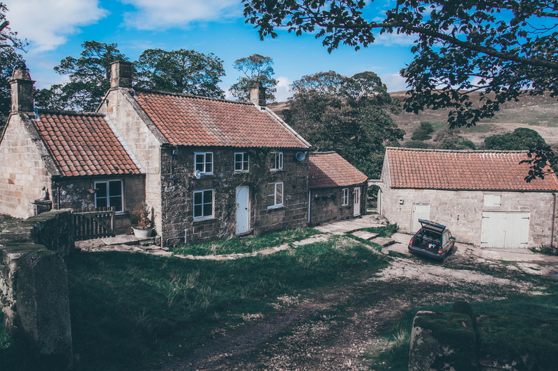 out buildings, tree, building, residential district, grass, no people, city, red roof, clouds, sky, farm, countryside, plant, car, house, building exterior