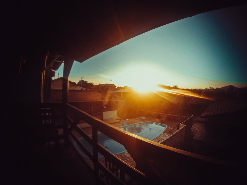 solar flare, building exterior, transportation, city, trees, outdoors, 4K, sunlight, railing, lens flare, no people, pool, streaming, sky, sun, water