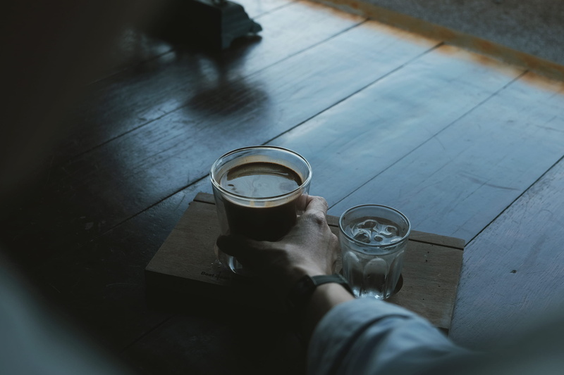 body part, personal perspective, high angle view, dark, drinking glass, cubes, clear, adult, wrist, water, human hand, holding, beside, flooring, ice, wooden