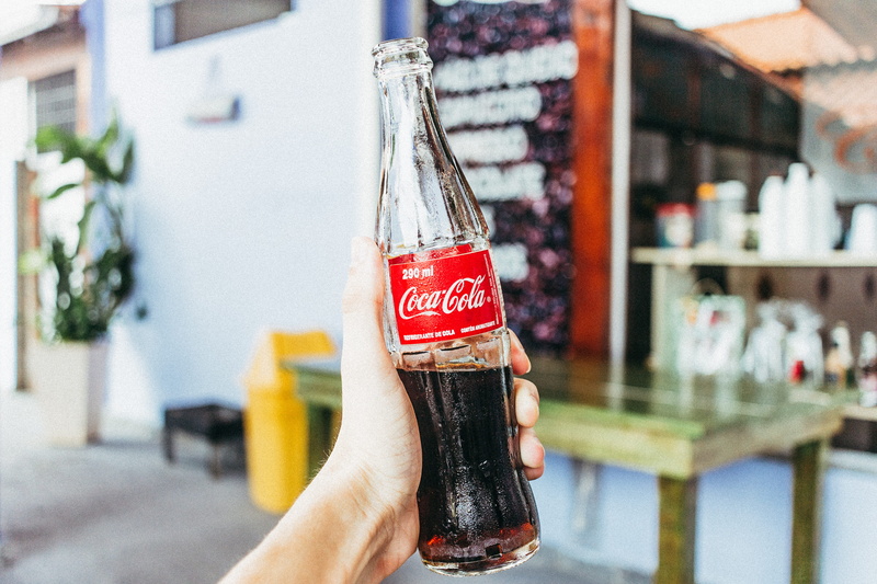 human finger, coca cola, alcohol, holding, person, refreshment, lifestyles, one person, container, drink, human limb, bottle, body part, glass, hand, food and drink