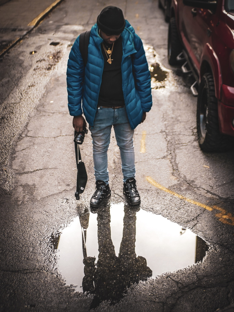 road, parked, electronics, full length, nature, looking down, reflection, man, jeans, device, street, after the rain, standing, real people, day, reflective