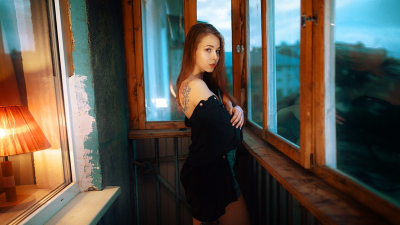 window, women, Andrew Erm, redhead, portrait, emotion, long hair, face, tattoo, balcony, black clothing, standing, no bra, dark eyes, 1080P, jean shorts