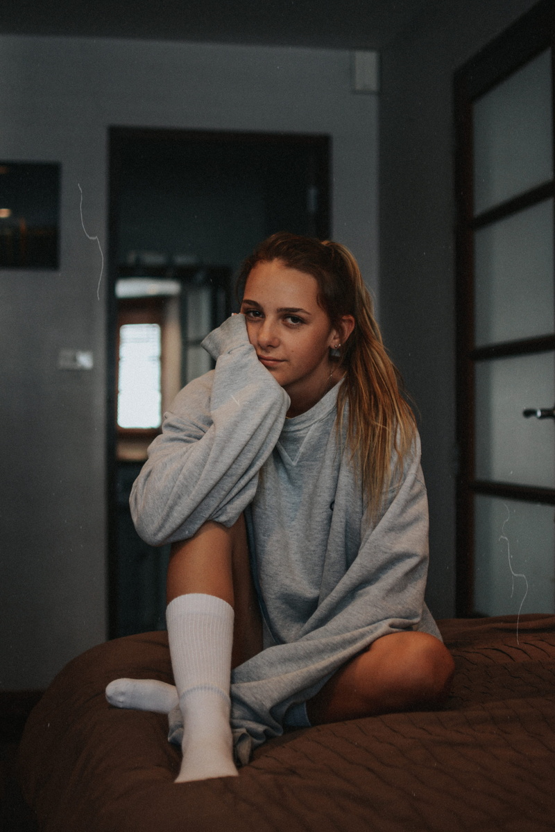 home interior, woman, person, bedroom, teenager, mood, casual clothing, wearing, lifestyles, girl, hairstyle, contemplation, dark, young adult, looking at camera