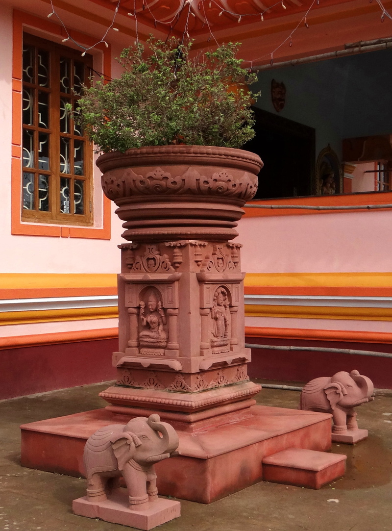 architectural column, day, motion, building, male likeness, ornate, plant, architecture, nature, podium, sculpture, holy basil, built structure, religion