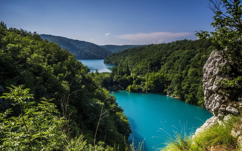 high angle view, turquoise, tranquility, plant, non-urban scene, forest, blue, tranquil scene, near, river, sky, hills, sea, mountain, day, growth, outdoors