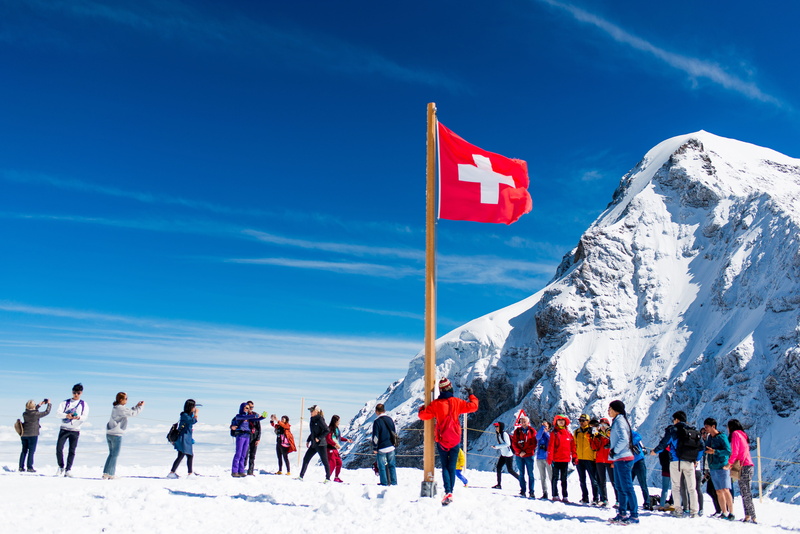 warm clothing, snow, scenics - nature, mountain, leisure activity, mountains, patriotism, lauterbrunnen, day, top of europe, winter, sky, outdoors, group of people