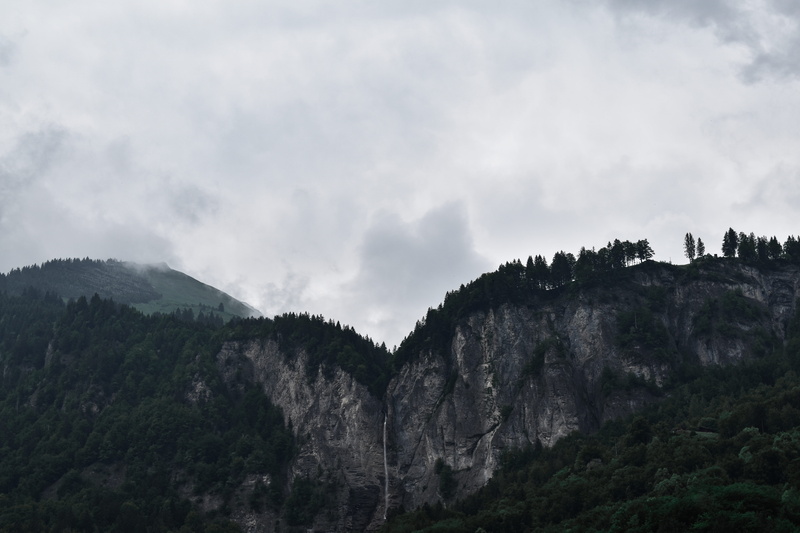 high, mountain, tranquil scene, cloud - sky, land, environment, rock, beauty in nature, cliff, travel, bluff, non-urban scene, landscape, trees, sky, mountain peak