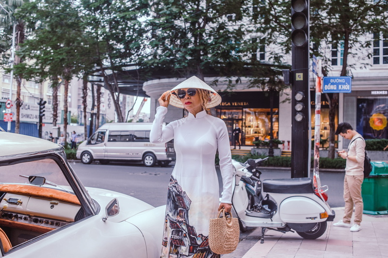 standing, transportation system, bag, adult, vehicle, side, land vehicle, scooter, car, architecture, beautiful, street, hat, ao dai, curb, motor vehicle