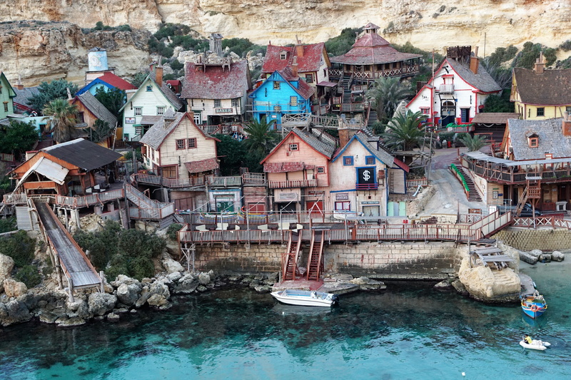 built structure, travel, buildings, outdoors, nature, popeye village, tourism, home, daytime, anchor bay, film, village, waterfront, blue, sea, land, wooden