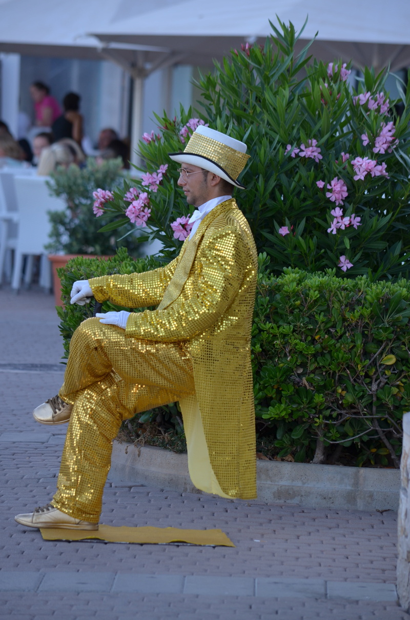 sitting, plant, sculpture, yellow, seat, architecture, clothing, outdoors, street artists, flower, real people, day, flower arrangement, incidental people