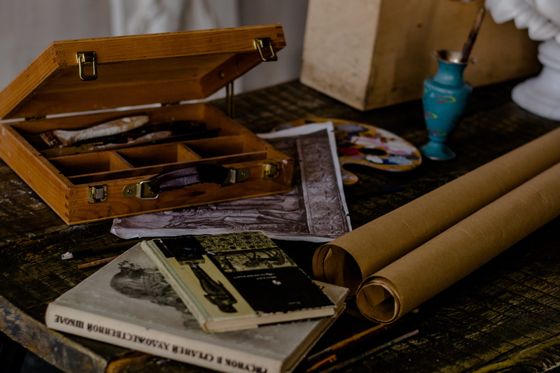 publication, text, id cards, day, wood - material, weapon, treasure, furniture, incense, male likeness, book, no people, weaponry, indoors, large group of objects
