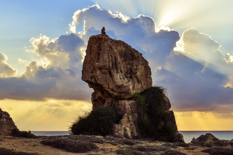 clouds, scenery, one person, solid, tranquil scene, cloud - sky, eroded, stone, beauty in nature, sea, shadows, archaeological site, paphos, rock, sunbeam