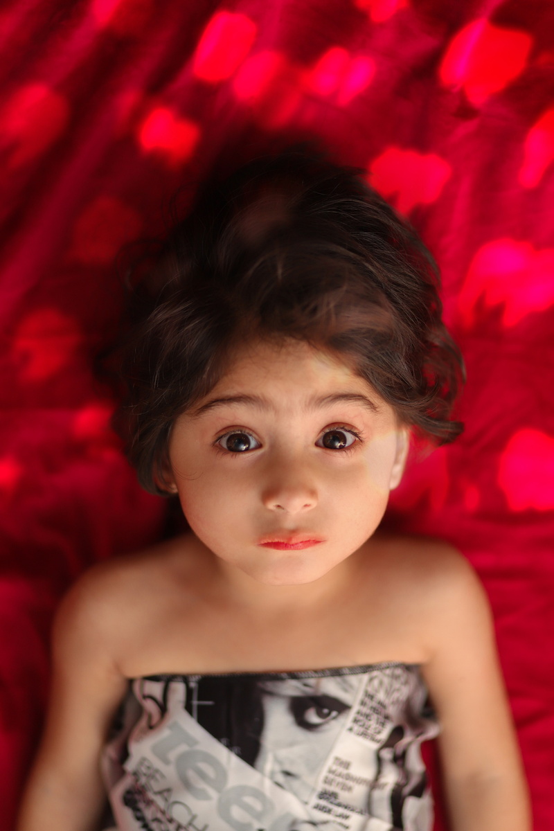 looking at camera, 5K, innocence, indoors, bangs, front view, one person, cute, emotion, headshot, brown eyes, children, happiness, top view, brown hair