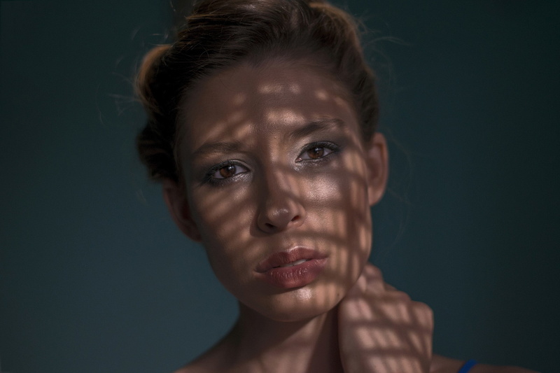beautiful woman, 1080P, looking at camera, simple background, one person, colored background, human body part, shadow, front view, dappled sunlight, black background