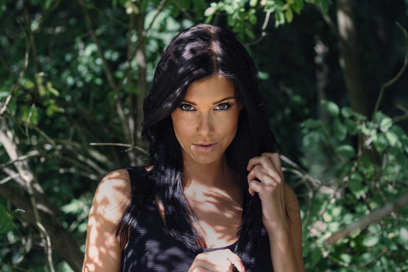 black hair, freckles, face, brunette, green eyes, depth of field, trees, smirk, women, portrait, women outdoors, dappled sunlight, 1080P