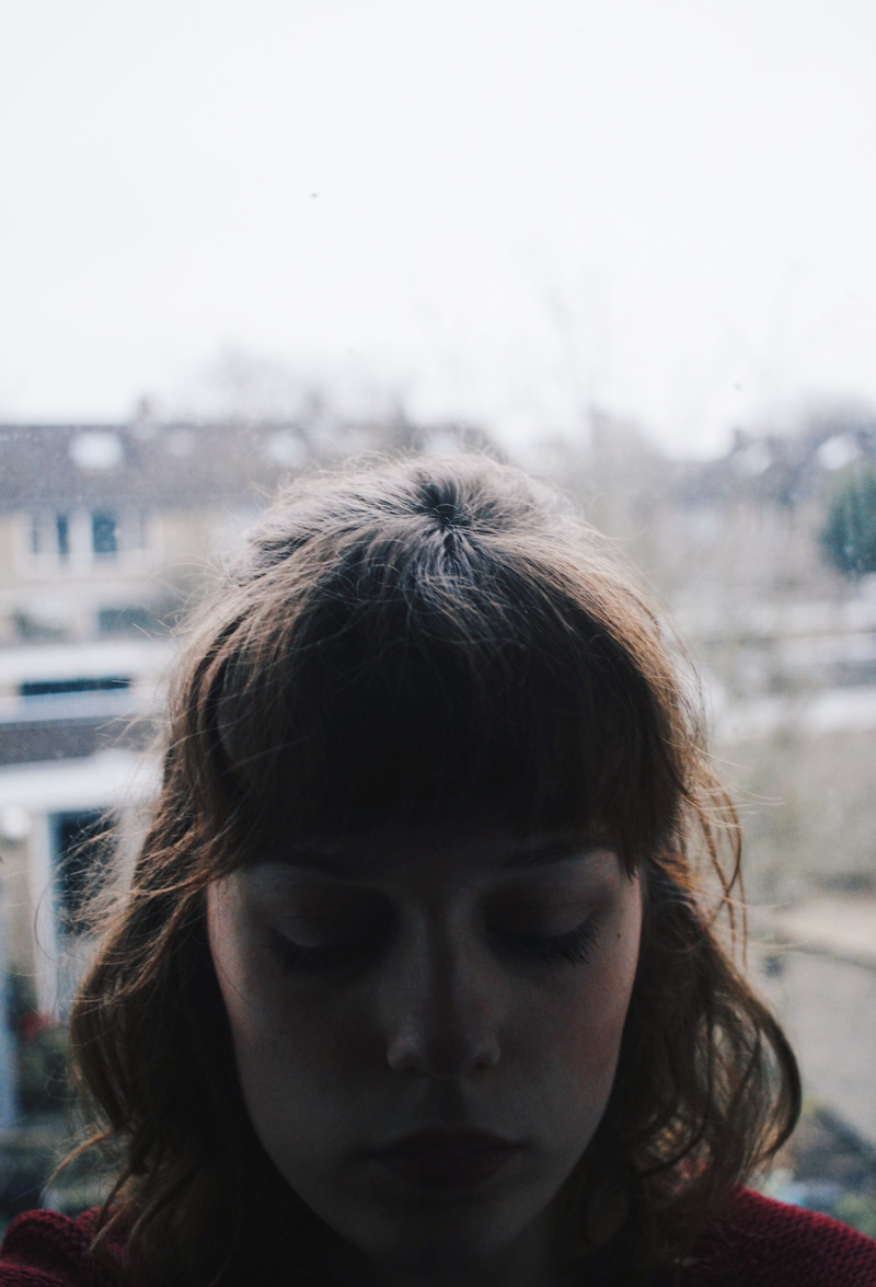 building exterior, human hair, looking, headshot, front view, architecture, boho, city, focus on foreground, outdoors, contemplation, window, young women