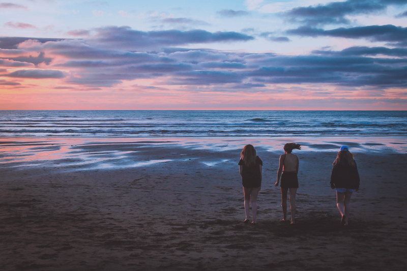 outdoors, sand, horizon over water, nature, beauty in nature, real people, beach, cloud - sky, water, piha, new zealand, rear view, ocean, breeze, group of people