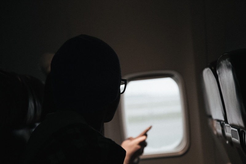 portrait, holding, inside, indoors, seats, motion, airplanes, sitting, window, person, landing, land vehicle, one person, cabin, plane, time, vehicle interior