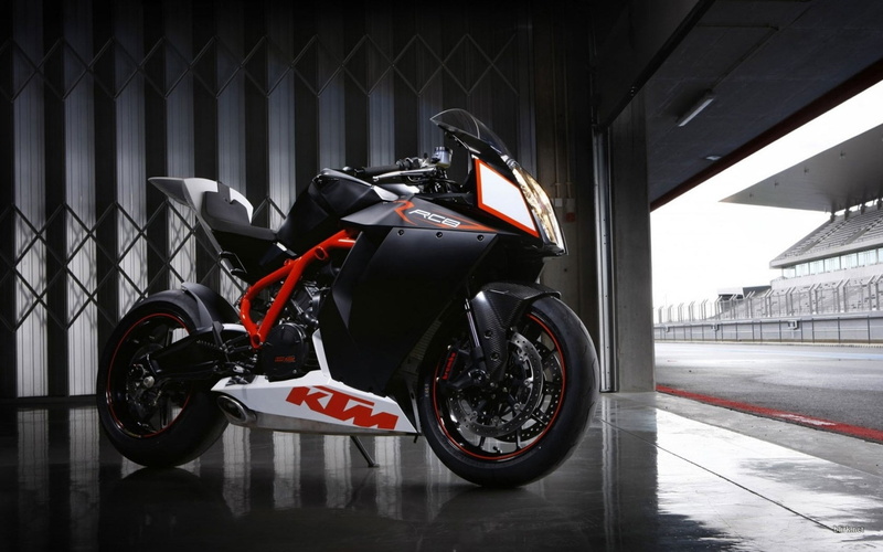 motorcycle, motorsport, outdoors, transportation, built structure, land vehicle, competition, tire, stationary, ktm rc8, auto racing, headwear, city, speed