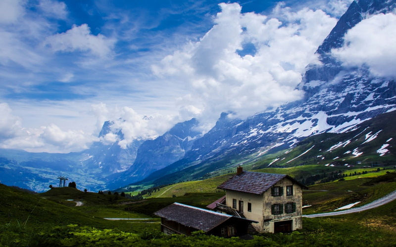 mountains, environment, sky, snowcapped mountain, beauty in nature, house, no people, valley, tranquil scene, architecture, grass, cloud - sky, built structure