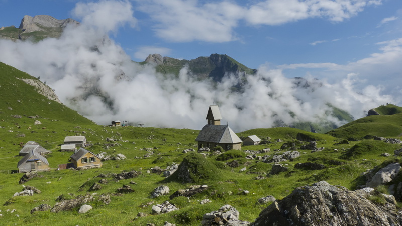 field, hiking, no people, grass, houses, environment, concrete, building exterior, green color, beauty in nature, cloud - sky, non-urban scene, travel destinations