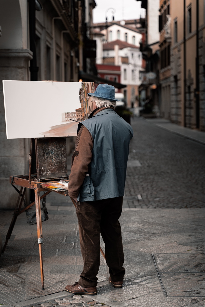 person, man, shoe, full length, wood, standing, real people, human, hat, men, outdoors, near, street, easel, building exterior, tones, sidewalk, casual clothing
