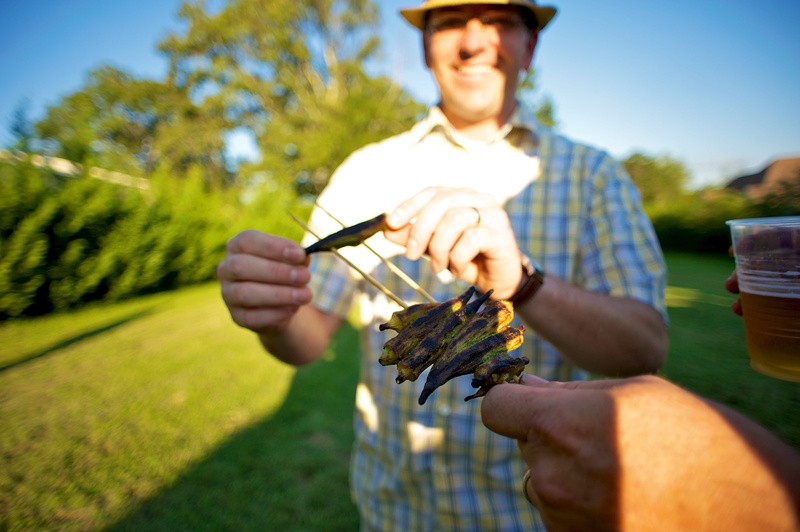 sunlight, holding, day, grill, front view, nature, one person, men, casual clothing, adult, young adult, grass, plant, bbq, mid adult, mid adult men, peppers