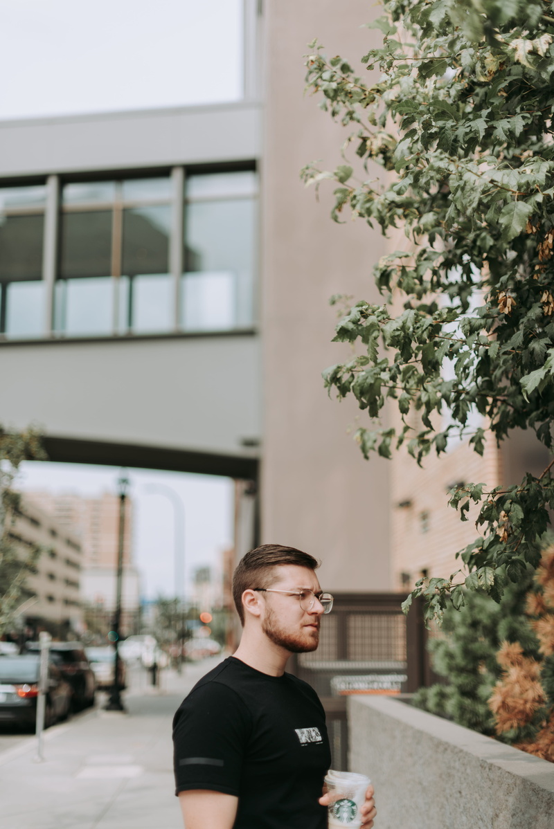 building exterior, lilac, blossom, city, focus on foreground, outdoors, front, holding, person, standing, looking away, united states, architecture, daytime