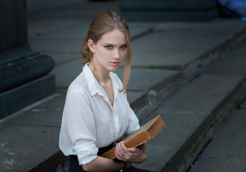 hair, 1080P, blue eyes, books, hairstyle, looking at camera, beautiful woman, one person, blonde, women, face, focus on foreground, model, standing, leisure activity