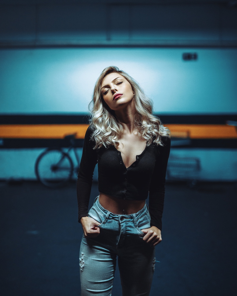 closed eyes, pierced navel, parking lot, parking, frontal view, depth of field, model, blonde, 4K, jeans, bycicle, portrait display, belly, cleavage, torn jeans