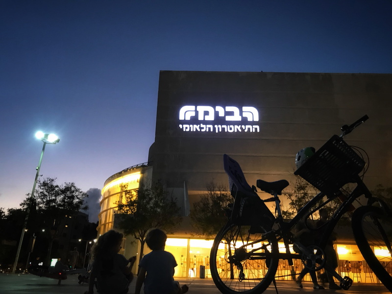 mode of transportation, western script, tel aviv-yafo, real people, sky, building exterior, israel, kids, lights, text, street, tel aviv, night, outdoors