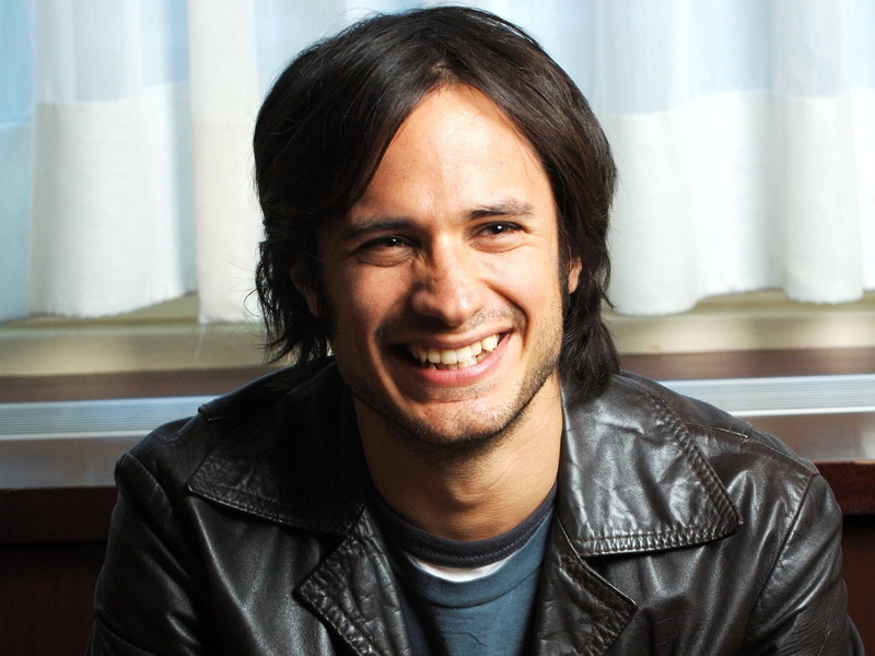 casual Clothing, indoors, cheerful, toothy Smile, young Adult, comfortable, laughing, relaxation, confidence, headshot, human Face, positive Emotion, gael garcia bernal