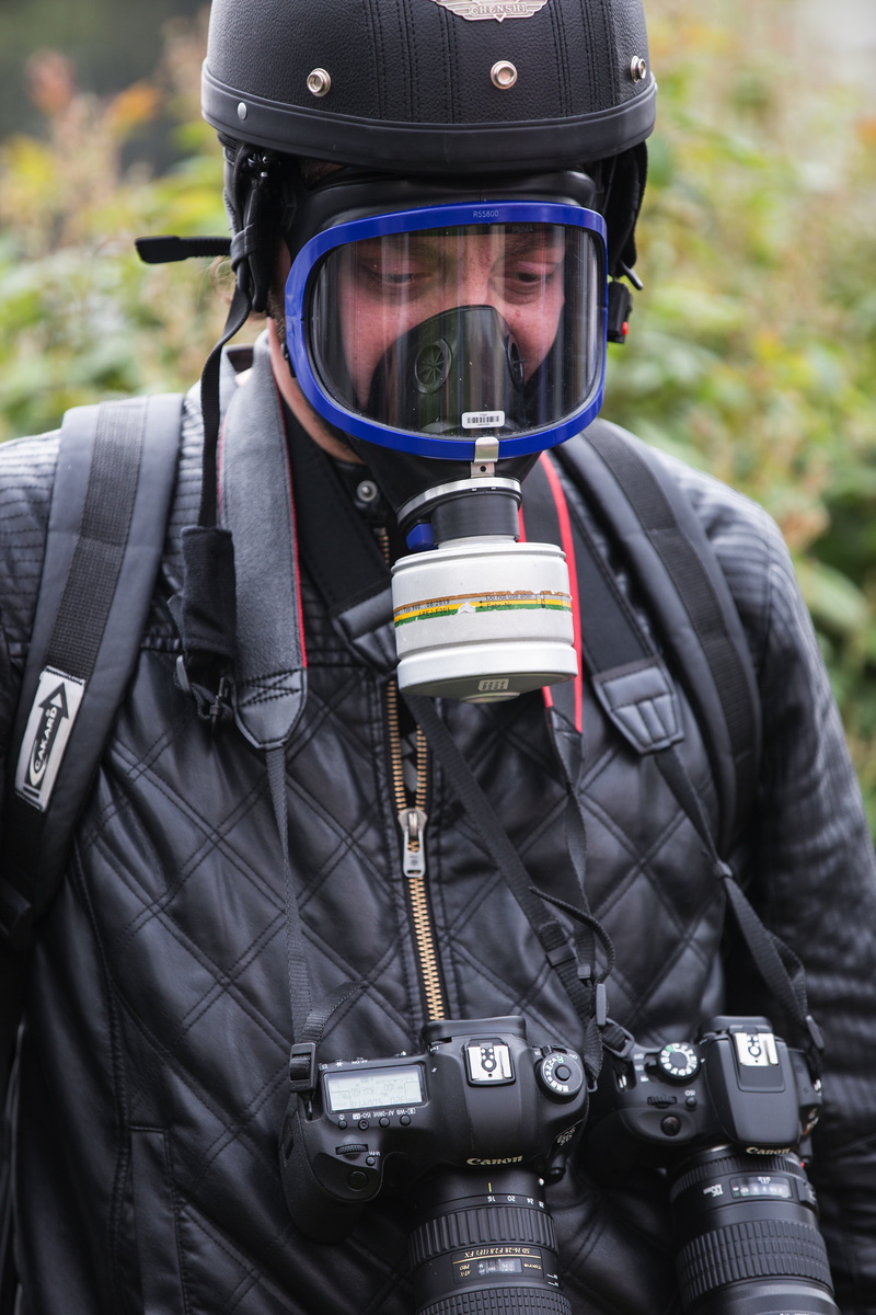 people, attack, gas mask, waist up, press, war, security, uniform, violence, one person, leather, holding, clothing, eyes, scuba diving, reporter, focus on foreground