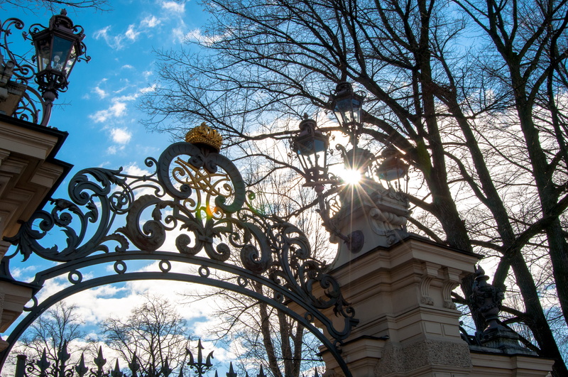 built structure, human representation, cloud - sky, branch, sights, outdoors, gate, grille, building, low angle view, representation, metal, boom, sky